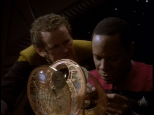 Screenshot: O'Brien plots while Sisko assembles a clock.