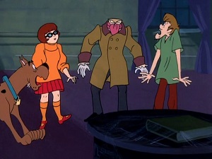 Screenshot: The headless spectre drops in on Shaggy, Scooby, and Velma.