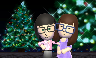 Gina and Tina take a quasi-romantic photo before a Christmas tree backdrop.